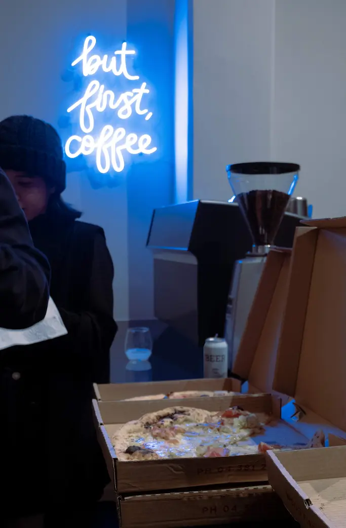 Box of pizza with a coffee machine in the background