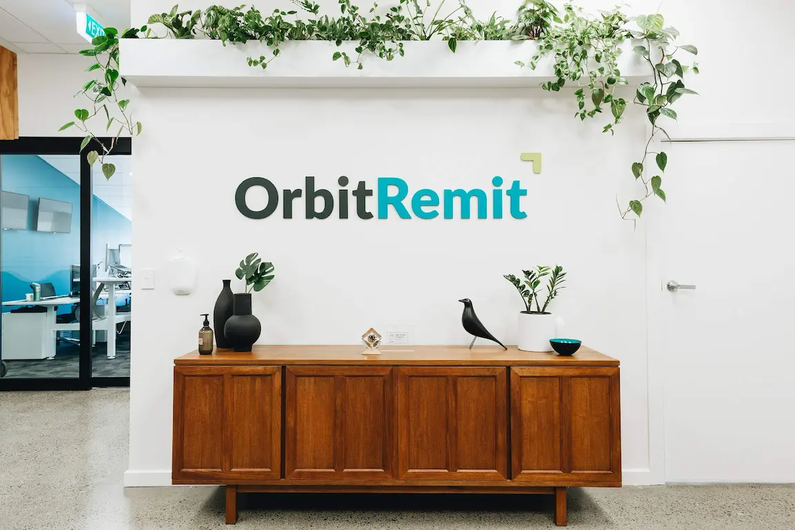 A wall with the OrbitRemit logo